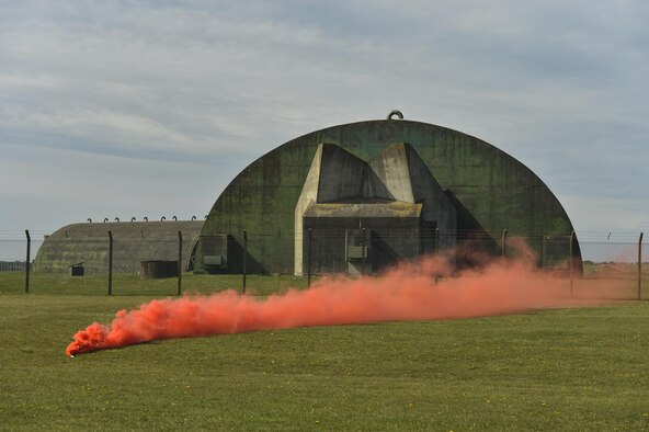 A smoke grenade marks the landing zone on the flightline of Royal Air Force Lakenheath, England, to start a combat search and rescue demonstration conducted for a group of Air Force civic leaders April 21, 2016. Air Force civic leaders are unpaid advisers, key communicators and advocates for the Air Force. (U.S. Air Force photo/Tech. Sgt. Joshua DeMotts)