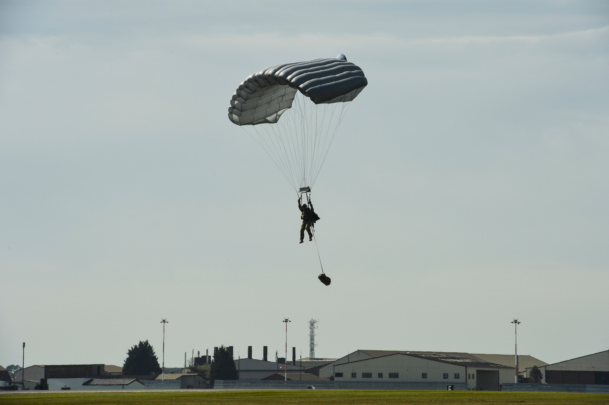 A pararescueman with the 57th Rescue Squadron parachutes onto the flightline at Royal Air Force Lakenheath, England, during a combat search and rescue demonstration conducted April 21, 2016, for a group of Air Force civic leaders, who are unpaid advisers, key communicators and advocates for the Air Force. (U.S. Air Force photo/Tech. Sgt. Joshua DeMotts)