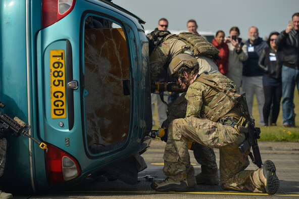 Pararescuemen with the 57th Rescue Squadron cut through a car with power tools to rescue a simulated trapped Airman at Royal Air Force Lakenheath, England, as they conduct a combat search and rescue demonstration April 21, 2016, for a group of Air Force civic leaders, who serve as unpaid advisers, key communicators and advocates for the Air Force. (U.S. Air Force photo/Tech. Sgt. Joshua DeMotts)