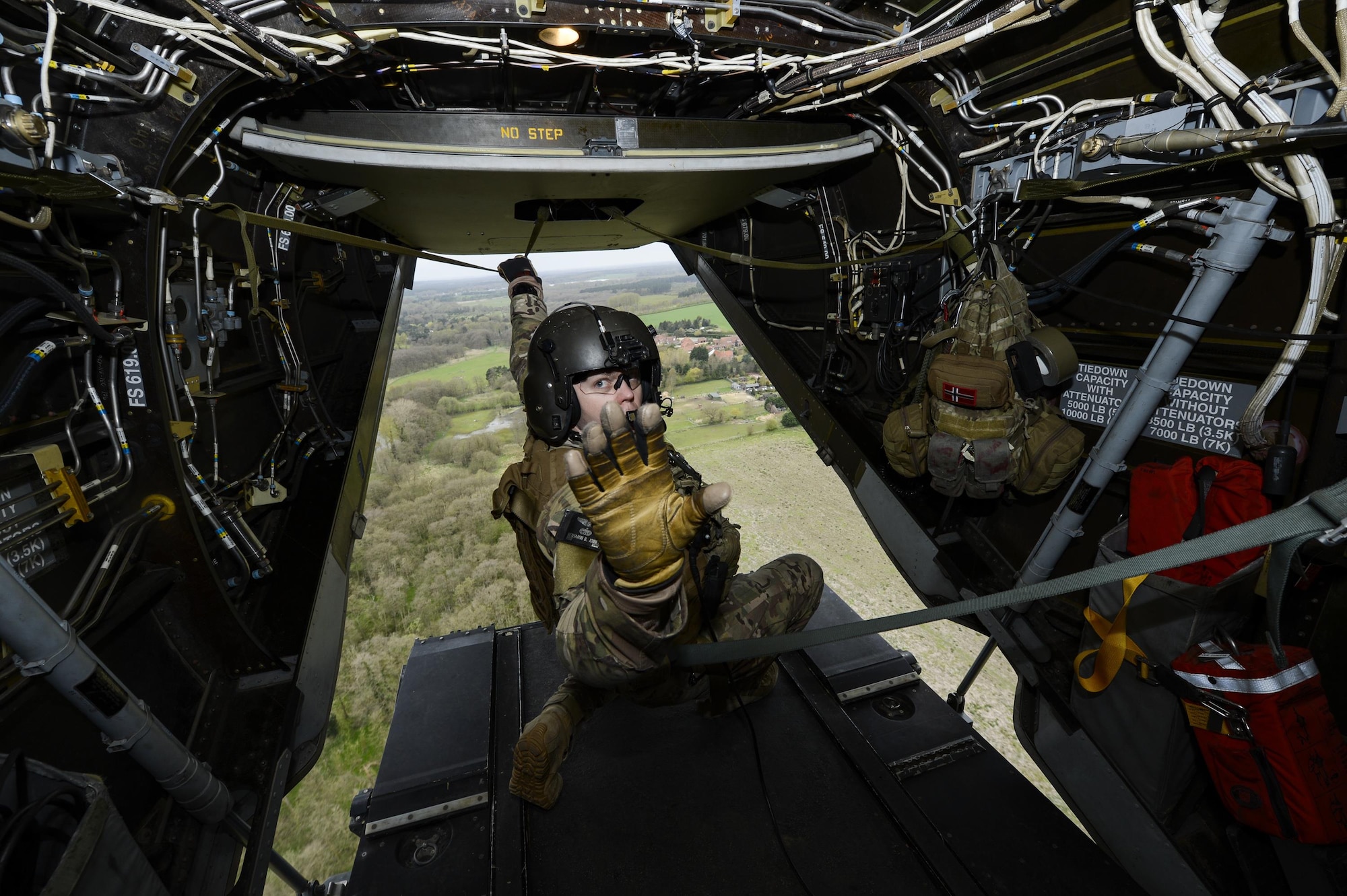 Master Sgt. Benjamin Joiner, a CV-22 Osprey flight engineer with the 352nd Special Operations Wing on Royal Air Force Mildenhall, England, signals to passengers during an orientation flight April 19, 2016, during a weeklong civic leader trip to several bases in Europe. Air Force civic leaders are unpaid advisers, key communicators and advocates for the Air Force. (U.S. Air Force photo/Tech. Sgt. Joshua DeMotts)