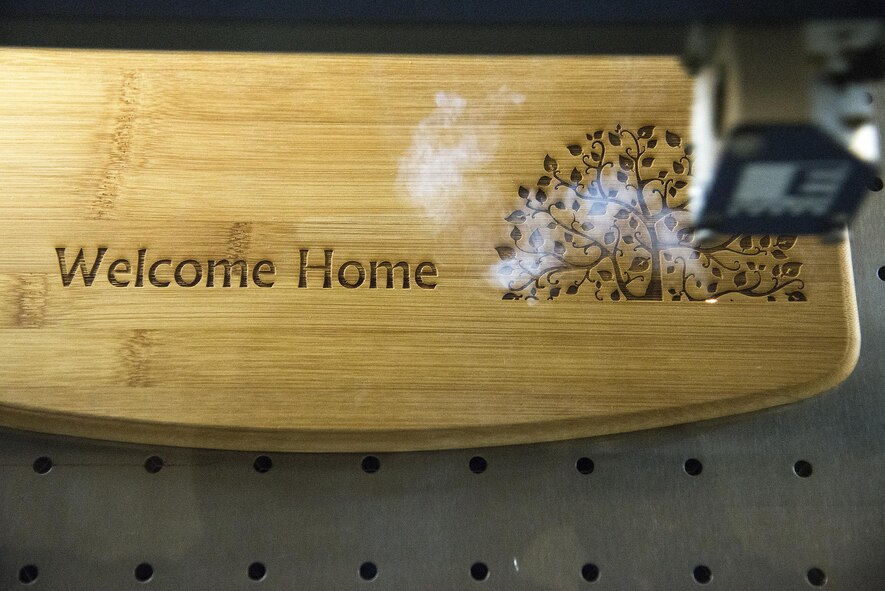 A laser fusion system engraves an image into a plaque of wood, May 4, 2016, at Moody Air Force Base, Ga. The plaque and frame section of The Shop can engrave various materials such as: wood, glass, metal and bottles. (U.S. Air Force photo by Airman 1st Class Janiqua P. Robinson/Released)
