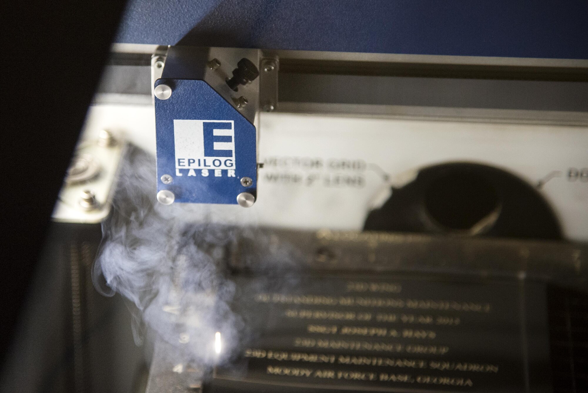 A laser fusion system cuts out engraved plates, May 4, 2016, at Moody Air Force Base, Ga. The machine uses lasers to engrave and cut various materials that are given as gifts and awards. (U.S. Air Force photo by Airman 1st Class Janiqua P. Robinson/Released)