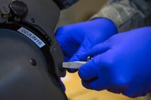 A U.S. Air Force Airman from the 347th Operations Support Squadron aircrew flight equipment shop loosens a thumbscrew from the visor assembly of an HGU-56P helmet, May 5, 2016, at Moody Air Force Base, Ga. Airmen from the 347th OSS AFE shop inspect approximately 50 helmets for Moody’s HH-60G Pave Hawk pilots per month. (U.S. Air Force photo by Airman 1st Class Greg Nash/Released) 