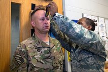 U.S. Air Force Senior Airman Aaron Blaylock, 347th Operations Support Squadron aircrew flight equipment journeyman, conducts a HGU-56P helmet measurement for Chief Master Sgt. David Kelch, 23d Wing command chief, prior to his fini-flight, May 5, 2016, at Moody Air Force Base, Ga. AFE specialists manage the inspection, maintenance and adjustments of Moody’s A-10 C Thunderbolt II, HC-130J Combat King and HH-60G Pave Hawk aircraft equipment. (U.S. Air Force photo by Airman 1st Class Greg Nash/Released) 
