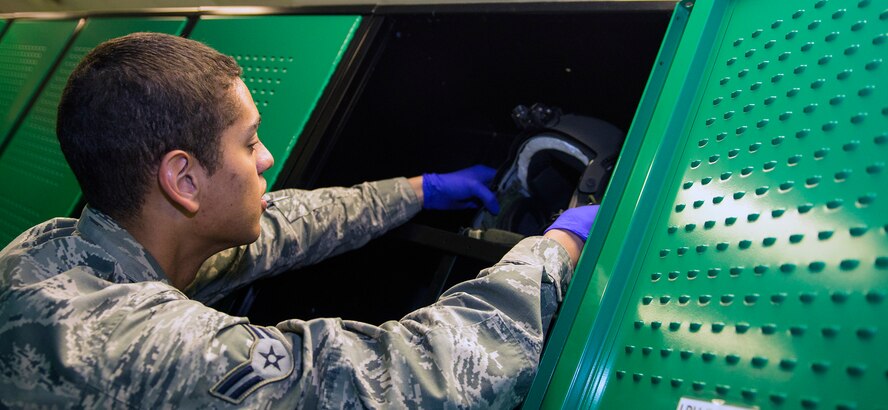 U.S. Air Force Airman 1st Class Ryan Utley, 347th Operations Support Squadron aircrew flight equipment journeyman, places a mission-ready HGU-56P flight helmet inside of a locker, May 5, 2016, at Moody Air Force Base, Ga. The 347th OSS AFE specialists directly support approximately 90 HH-60G Pave Hawk aircrew member’s flight equipment. (U.S. Air Force photo by Airman 1st Class Greg Nash/Released)