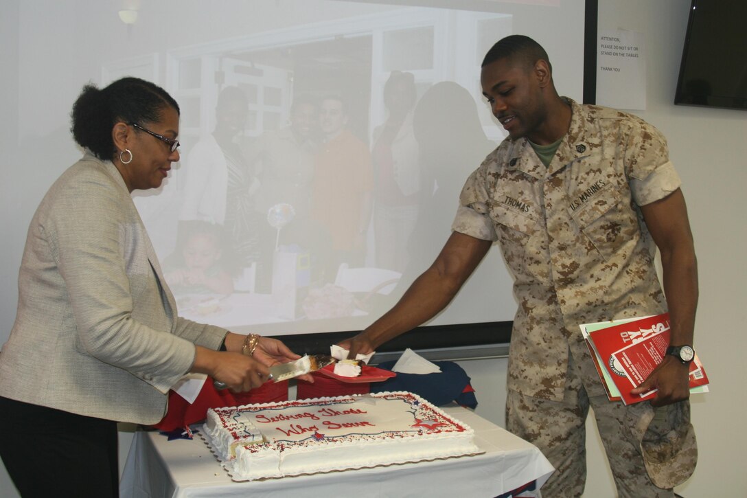 Melora McVicker, Education Services Officer with the Marine Corps Base Quantico Voluntary Education Center, hands a slice of cake to SSgt. Andre Thomas, MCNOSC, at the Military Student Appreciation Luncheon