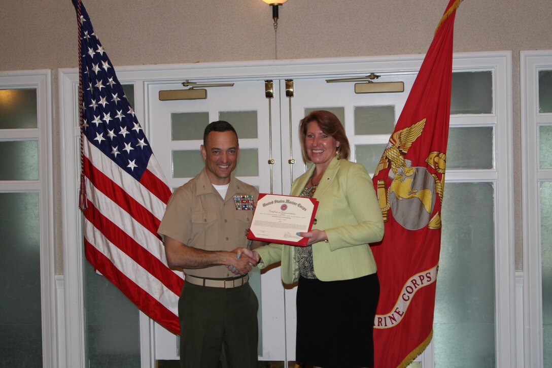 Col. Joseph Murray, Marine Corps Base Quantico commander, presents Dancy Simons, hearings officer for the office of the Staff Judge Advocate, with her award for Senior Civilian of the Quarter for the first quarter of 2016 at a ceremony held at The Clubs at Quantico April 28. Simons was commended for adjudicating more than 357 traffic citations, providing counsel to 24 supporting commands as the subject matter expert on enlisted administrative separations, and creating a process by which military confinees can receive haircuts during their judicial proceedings.