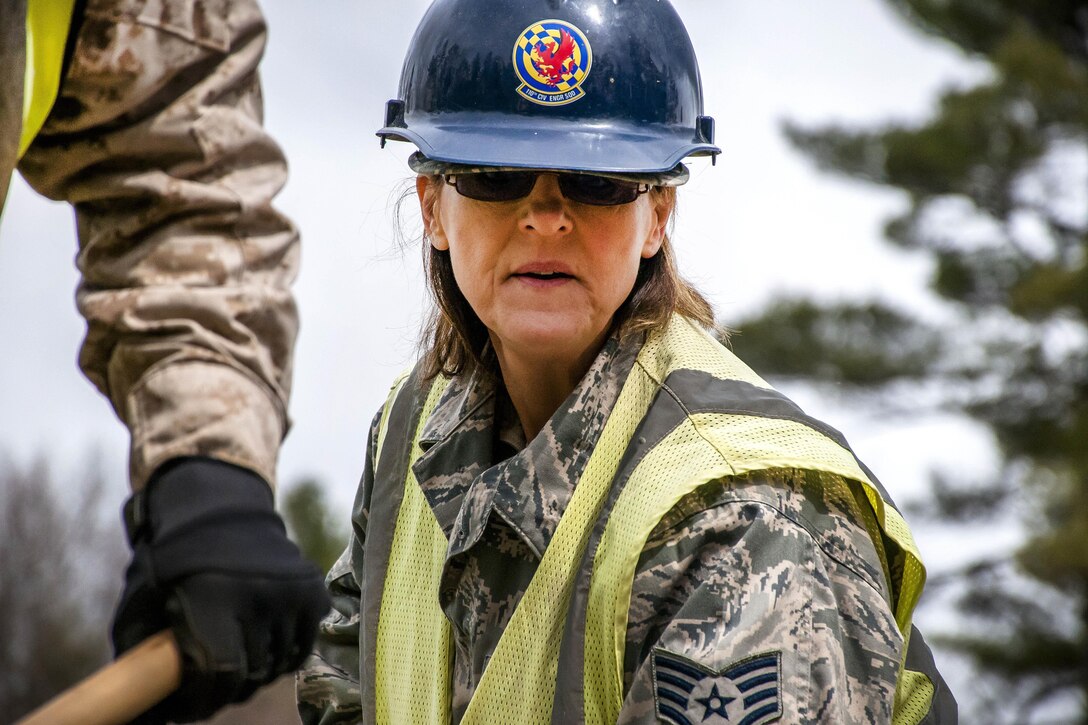 Air Force Staff Sgt. Mary Pesce levels wet concrete for the porch of a new dining facility at Camp Hinds in Raymond, Maine, May 3, 2016. Pesce is assigned to the 110th Attack Wing Civil Engineering Squadron. Air National Guard photo by Airman Tiffany Clark