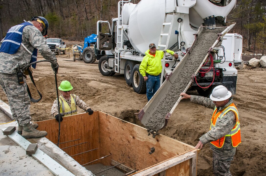 Airmen and Marine Reservists pour cement for a foundation to build a porch for a new dining facility at Camp Hinds in Raymond, Maine, May 3, 2016. Air National Guard photo by Airman Tiffany Clark