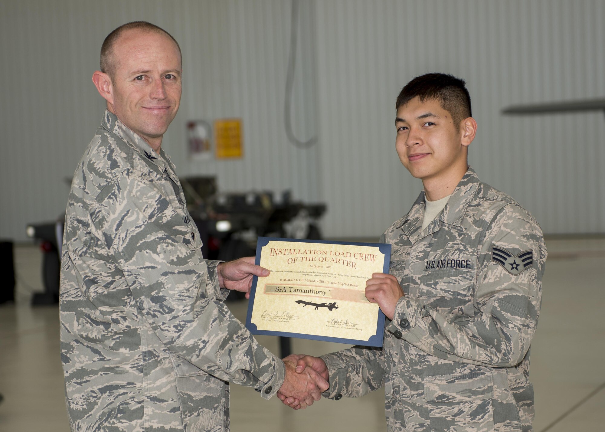 Col. Ryan Craycraft, the 49th Wing vice commander, presents an award to Senior Airman Tamanthony, a 49th Aircraft Maintenance Squadron load crew member from Holloman Air Force Base, N.M., after Tamanthony’s team won the annual load completion here May 4. Teams from the 54th Fighter Group and the 49th Aircraft Maintenance Squadron here competed by testing their ability to quickly load training weapon systems onto their respective aircraft. (Last names are withheld due to operational requirements) (U.S. Air Force photo by Airman 1st Class Randahl J. Jenson)   