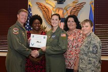 Capt. Rebecca Sullivan, 47th Flying Training Wing specialist for the primary prevention of violence and alternate sexual assault response coordinator, accepts the “XLer of the Week” award from Col. Thomas Shank, left, 47th FTW commander, and Chief Master Sgt. Teresa Clapper, right, 47th FTW command chief, here, April 27, 2016. The XLer is a weekly award chosen by wing leadership and is presented to those who consistently make outstanding contributions to their unit and Laughlin. (U.S. Air Force photo/Airman 1st Class Brandon May)