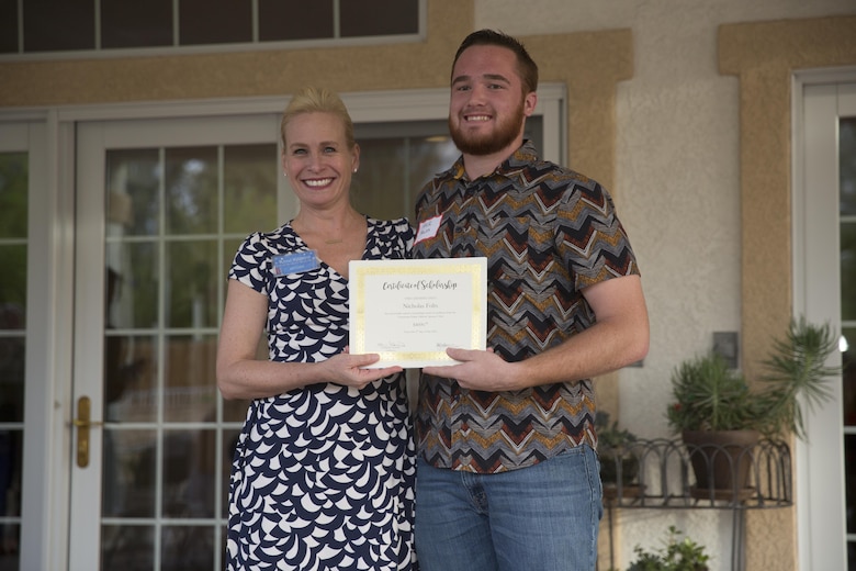 Kimberlee Eggers, vice president, Officers’ Spouses’ Club, presents a scholarship to Nicholas Folts during the annual OSC Scholarship and Grant Awards Reception at Quarters One May 3, 2016. (Official Marine Corps Photo by Cpl. Julio McGraw/Released)