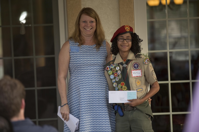 Matthew Perez, boy scout, Boyscout Troop 78, accepts a grant on behalf of his troop from Lisa Bargeron, grant committee chair person, Officers’ Spouses’ Club, during the annual OSC Scholarship and Grant Awards Reception at Quarters One May 3, 2016. (Official Marine Corps Photo by Cpl. Julio McGraw/Released)