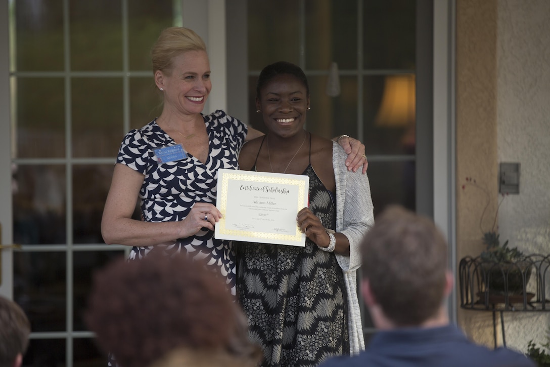 Kimberlee Eggers, vice president, Officers’ Spouses’ Club, presents a scholarship to Adriann Miller during the annual OSC Scholarship and Grant Awards Reception at Quarters One May 3, 2016. (Official Marine Corps Photo by Cpl. Julio McGraw/Released)