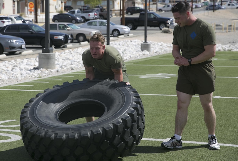 The 7th Marine Regiment team conducts tire flips at the West Gymnasium during the Amazing Sexual Assault Prevention and Response Race held aboard the Combat Center April 29, 2016. (Official Marine Corps photo by Cpl. Thomas Mudd/Released)