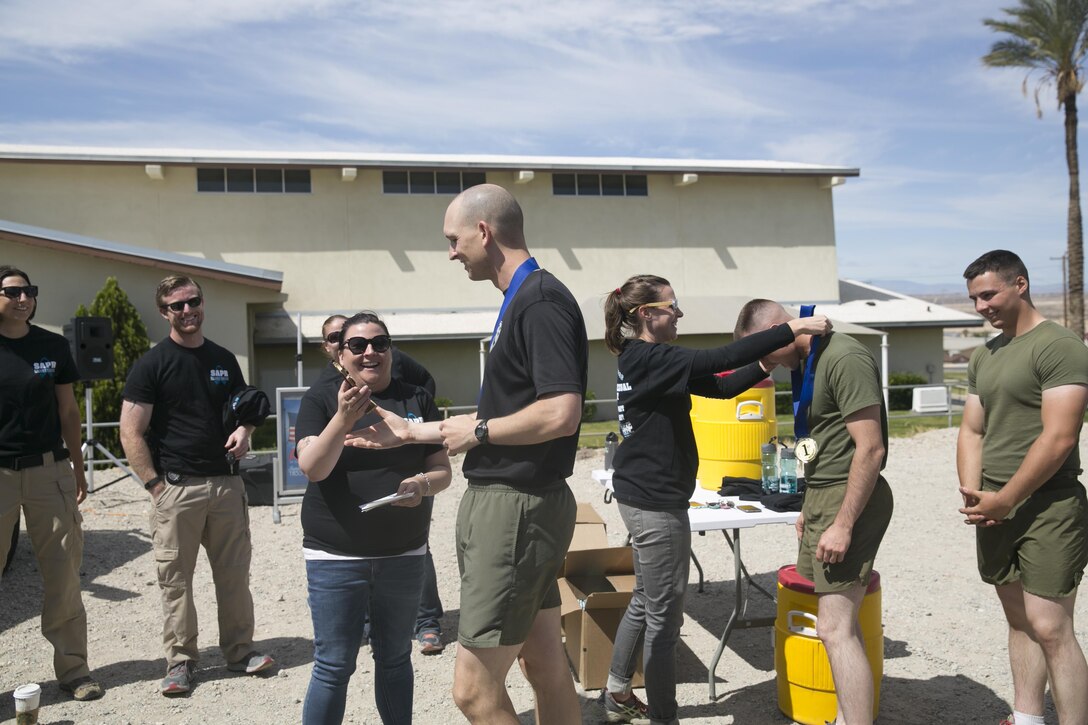 The 3rd Light Armored Reconnaissance Battalion team receive first place medals and a trophy at the Protestant Chapel during the conclusion of the Amazing Sexual Assault Prevention and Response Race held aboard the Combat Center April 29, 2016. (Official Marine Corps photo by Cpl. Thomas Mudd/Released)