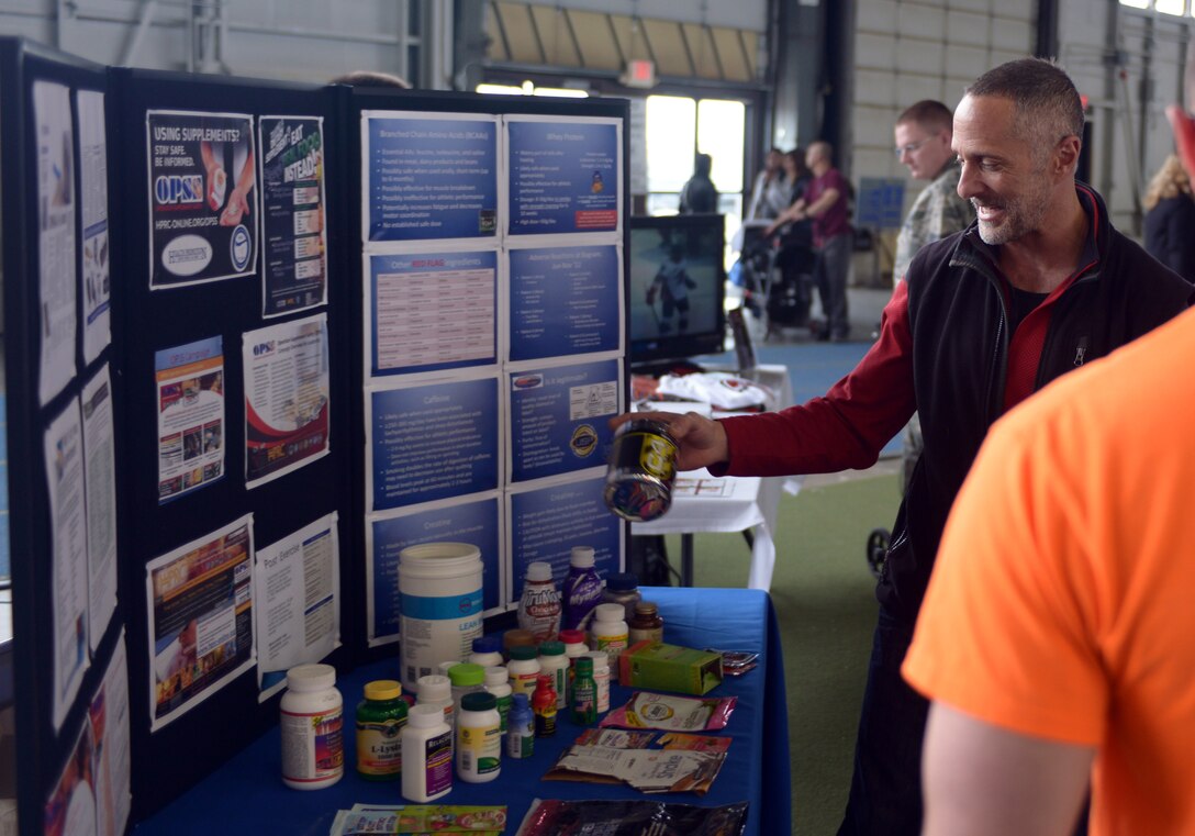 Cliff McArthur, 28th Medical Group dietitian, discusses supplements with families at the Pride Hangar during the Discover the Hills portion of Wingman and Spouse Appreciation Day at Ellsworth Air Force Base, S.D., April 29, 2016. McArthur is promoting the Health and Wellness Center with his booth, providing information about supplements and supplement safety. (U.S. Air Force photo by Airman Donald Knechtel/Released)