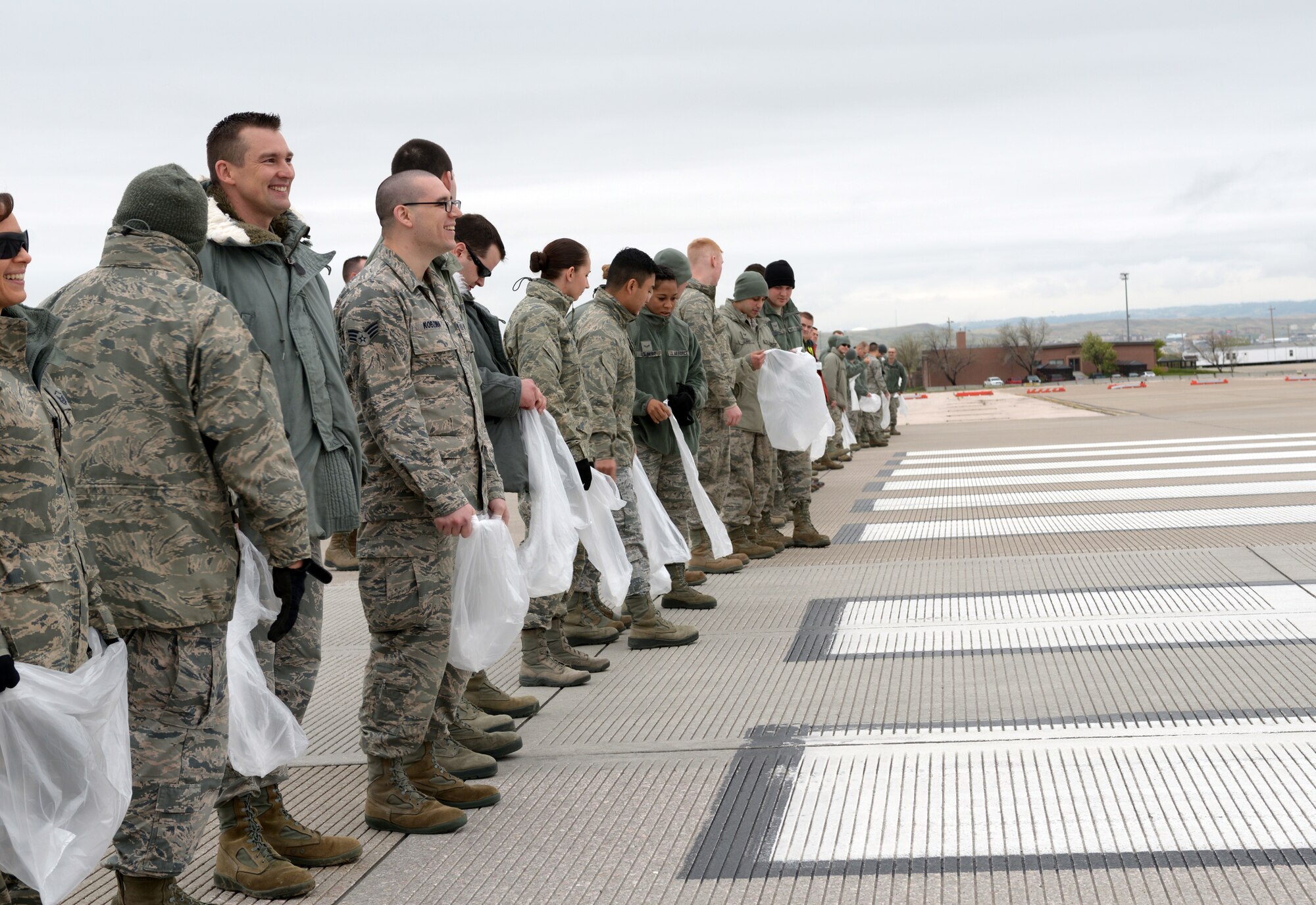 Airmen line up and prepare for a foreign object and debris walk at Ellsworth Air Force Base, S.D., April 29, 2016. To start off Wingman Day, Ellsworth Airmen conducted the FOD walk to clear the flightline of any debris that could damage aircraft engines during take-offs and landings. (U.S. Air Force photo by Airman Donald Knechtel/Released)