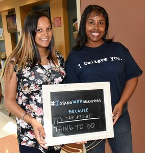 Petty Officer 2nd Class Brittney Aaron, left, an aviation ordnanceman, and Gloria Williams, a medical support assistant, both front desk clerks for the joint Physical Therapy Clinic of Naval Health Clinic Charleston and the Goose Creek Community Based Veterans Affairs Outpatient Clinic, show their support for sexual assault survivors during Denim Day April 22 at the joint facility. Staff members of NHCC and the VA wore denim jeans and donned
T-shirts with slogans to raise awareness of sexual assault prevention. (Navy photo/Kris Patterson)
