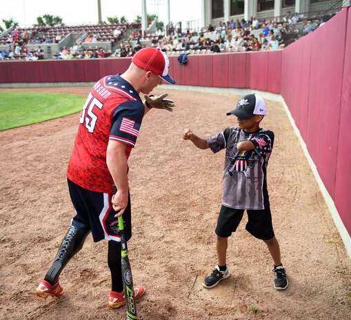 Frank Wasson, U.S. Army veteran, and Kayden Keitt, Wounded Warrior Softball Team batboy, mess around in the batter’s box April 23, 2016, at Patriot’s Point in Charleston, S.C. The WWAST is comprised of veterans and active-duty service members who have lost limbs but won’t let that disability to keep them from being competitive in athletics. They travel the country and play able-bodied softball teams competitively or through exhibition and celebrity games. (U.S. Air Force photo/Senior Airman Clayton Cupit)