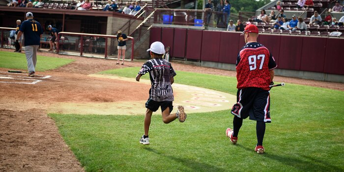Kayden Keitt, Wounded Warrior Softball Team batboy, runs to retrieve a bat as Daniel Lopez, U.S. Army veteran, walks up to bat April 23, 2016, at Patriot’s Point in Charleston, S.C. The WWAST is comprised of veterans and active-duty service members who have lost limbs but won’t let that disability to keep them from being competitive in athletics. They travel the country and play able-bodied softball teams competitively or through exhibition and celebrity games. (U.S. Air Force photo/Senior Airman Clayton Cupit)