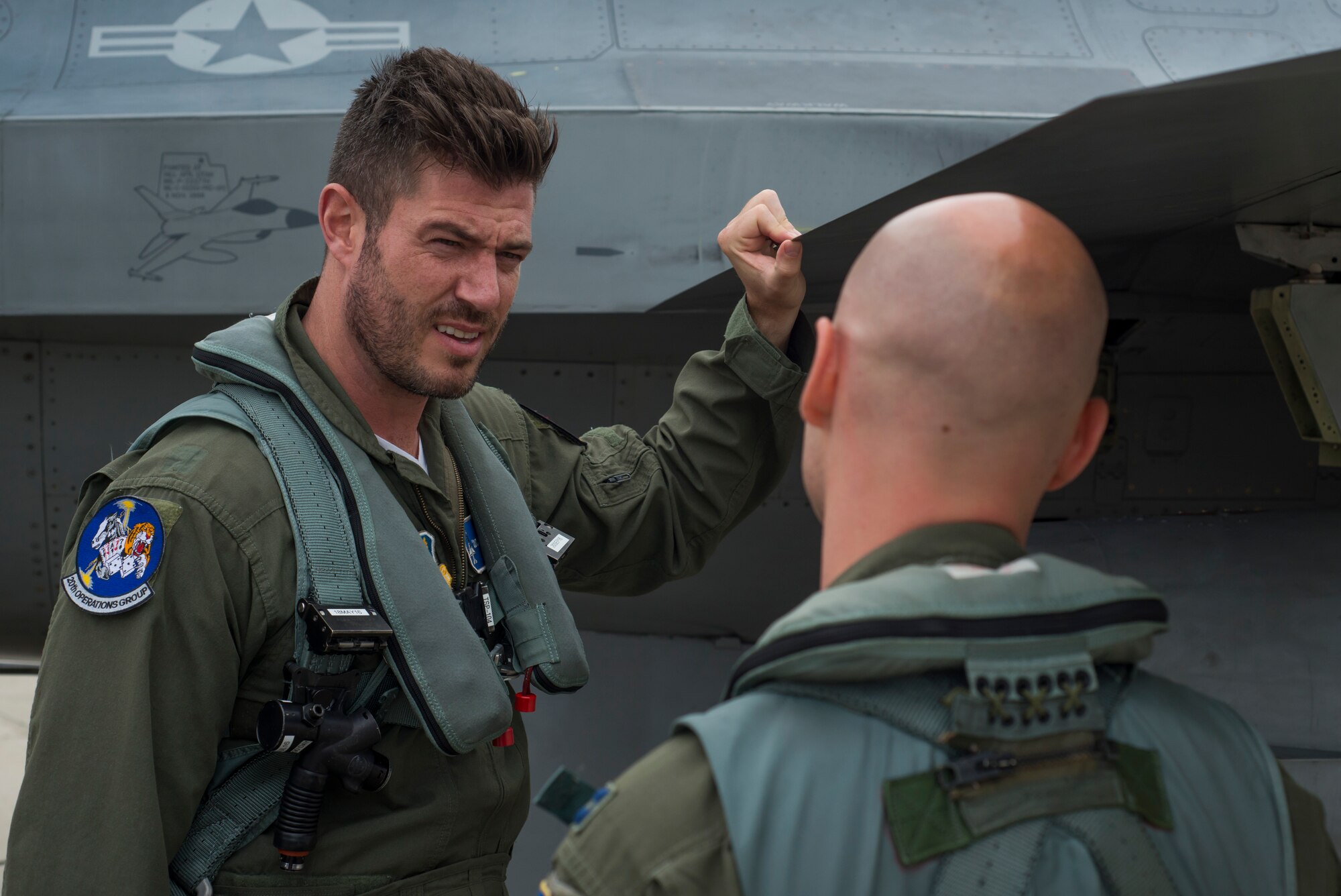 U.S. Air Force Capt. Michael Watts, F-16 Fighting Falcon pilot, explains the aircraft to Jesse Palmer, correspondent for ABC’s Good Morning America, prior to their flight at Langley Air Force Base, Va., May 3, 2016. The F-16 is a multirole fighter jet that is compact and highly maneuverable, with a high-performance weapons system. (U.S. Air Force photo by Senior Airman Kayla Newman)
