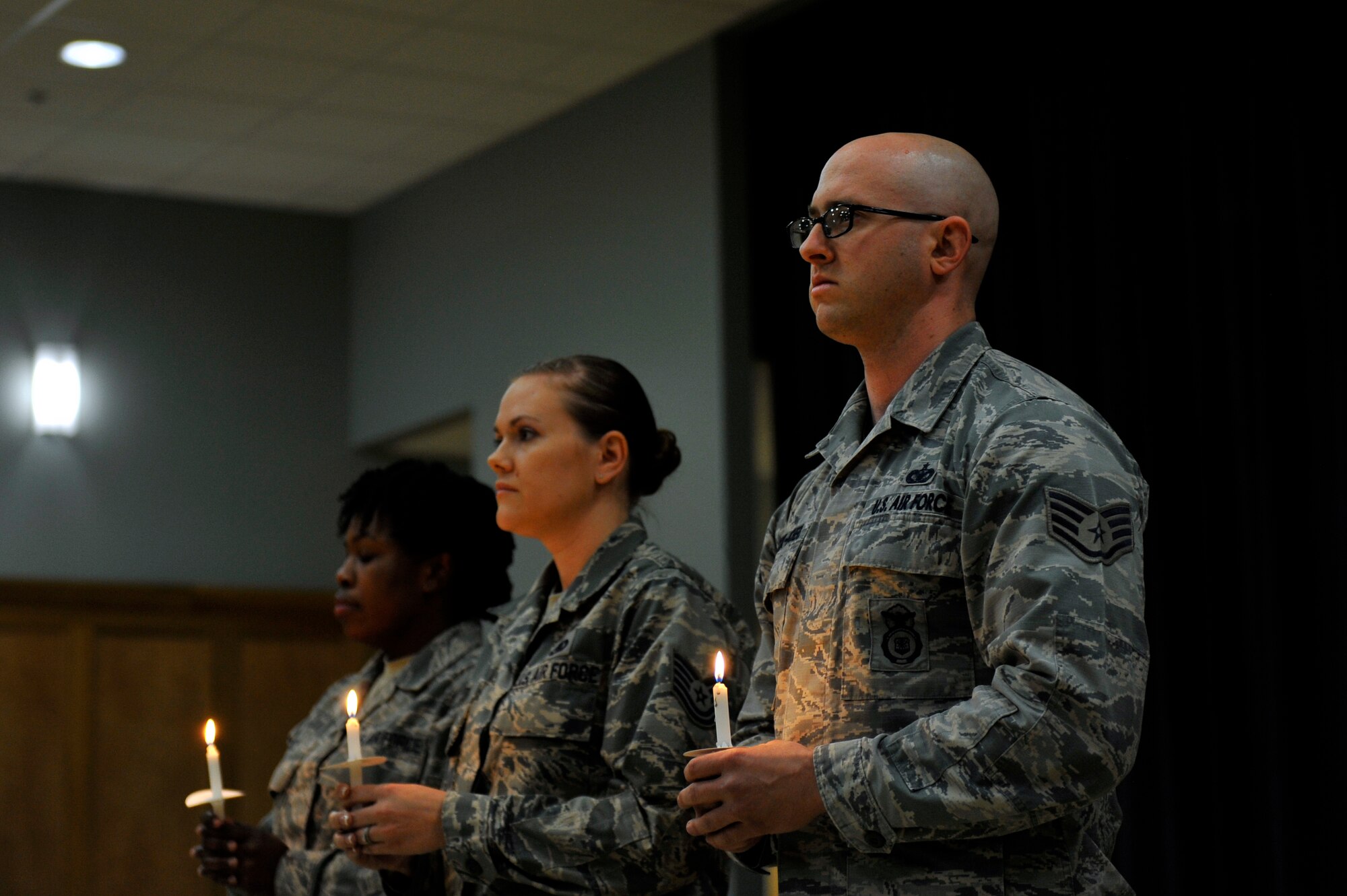 U.S. Air Force Airmen participate in the candle lighting portion of the Holocaust Remembrance Ceremony May 5, 2016, at Little Rock Air Force Base.  Lighting a candle signifies passing the light of memory and hope from one person to another. (U.S. Air Force photo by Kevin E. Sommer Giron) 
