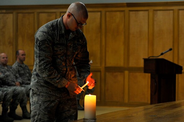 U.S. Air Force Staff Sgt. Austin Babcock-Kochera, 19th Security Forces, lights a candle during the Holocaust Memorial Ceremony May 5, 2016, at Little Rock Air Force Base. The candle lighting portion of the ceremony was in remembrance of the 6 million Jews who were killed during the Holocaust.  (U.S. Air Force photo by Kevin E. Sommer Giron)