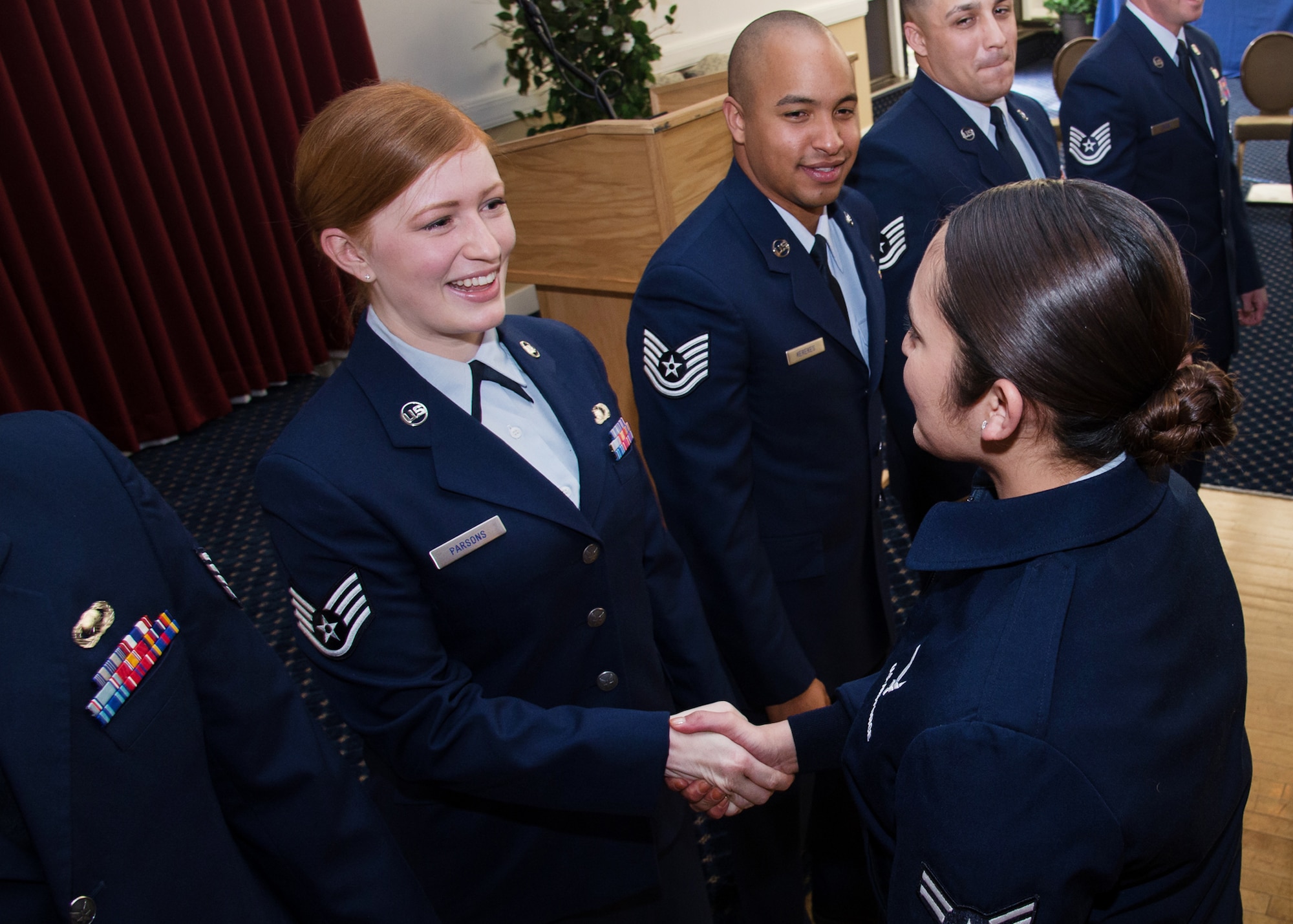 Staff Sgt. Lauren E. Parsons, 66th Comptroller Squadron customer service technician, is congratulated by Airman 1st Class Michele Anderson, 66th Air Base Group admin support, during the May Monthly Enlisted Promotion Ceremony at the Minuteman Commons April 29. Parsons was among seven Airmen recognized during the monthly event. (U.S. Air Force photo by Walter Santos)