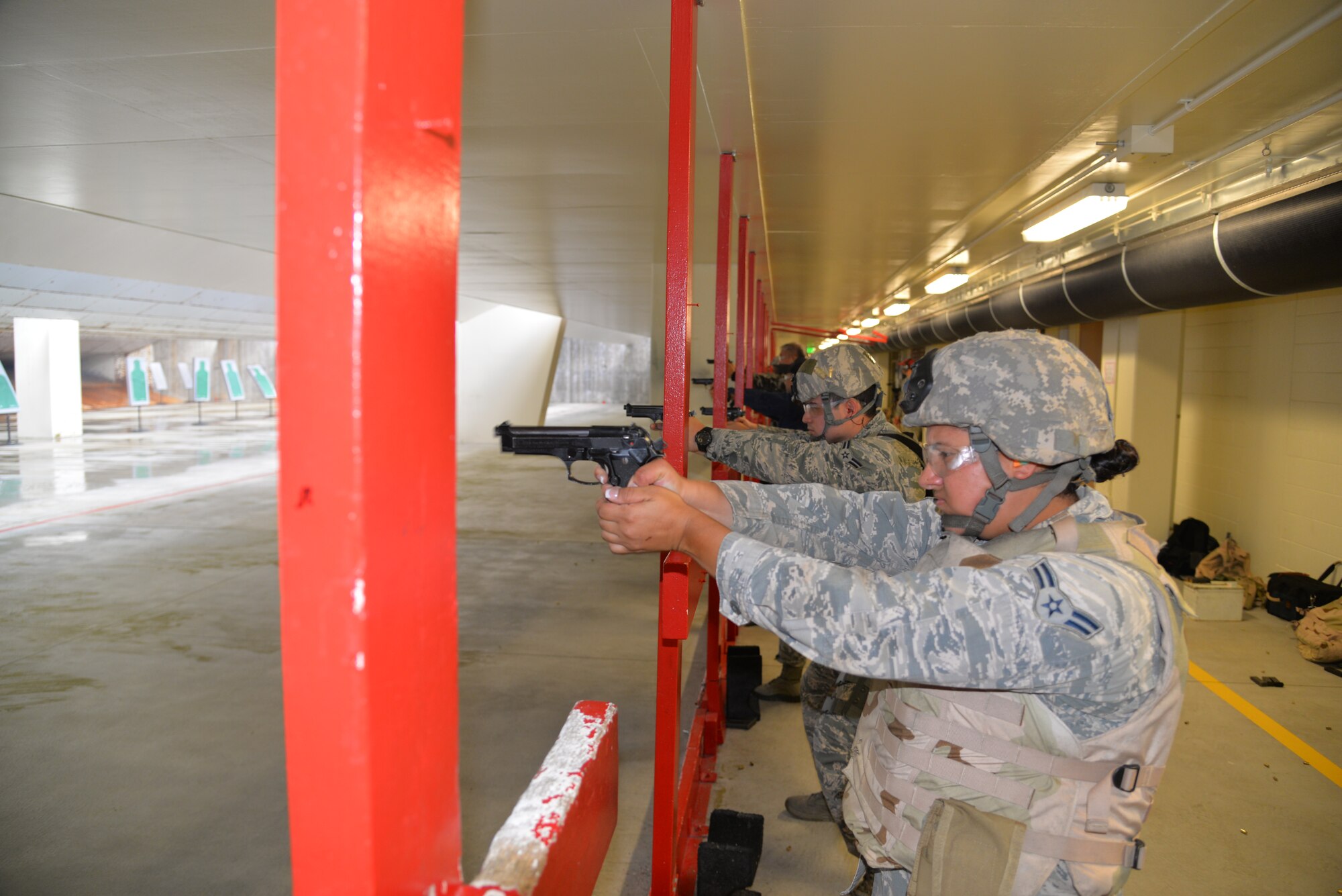 Airmen assigned to the 18th Security Forces Squadron fire their M9 pistols during a quick-firing course inside the combat arms training and maintenance facility April 28, 2016, at Kadena Air Base, Japan. Defenders fire their assigned pistols regularly along with other mission-specific training and use the CATM range to ensure success. (U.S. Air Force photo by Staff Sgt. Benjamin Sutton) 