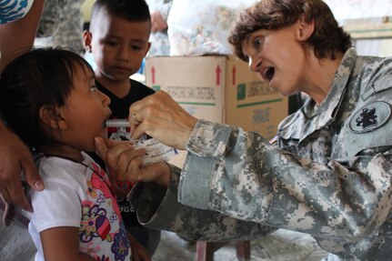 U.S. Army Capt. Katherine Matteson, Joint Task Force-Bravo Medical Element public health nurse, provides de-worming medication to a young girl during a Medical Readiness Training Exercise at Jocotán, Chiquimula, Guatemala, April 29, 2016. Vitamins and de-worming medication were provided for both children and adults during a preventive medicine health class prior to patients seeing the medical and dental providers.  (U.S. Army photo by Maria Pinel)