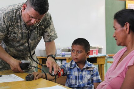 U.S. Army Sgt. Hiram Nieves, Joint Task Force-Bravo Medical Element, examines a young boy during a Medical Readiness Training Exercise at Ostumán, Copán, Honduras, April 28, 2016. The examination is part of a screening process that will determine the type of treatment needed by the patients before visiting the medical providers and pharmacy, where the appropriate treatment and medication is provided free of cost.  (U.S. Army photo by Maria Pinel)