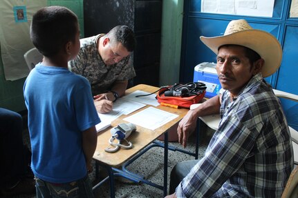 U.S. Army Sgt. Hiram Nieves, Joint Task Force-Bravo Medical Element, fills out a prescription for a Guatemalan man and his son during a Medical Readiness Training Exercise in Jocotán, Chiquimula, Guatemala, April 29, 2016. The designated area for the MEDRETE has high rates of malnutrition and parasitic infections that can lead to anemia. (U.S. Army photo by Maria Pinel)