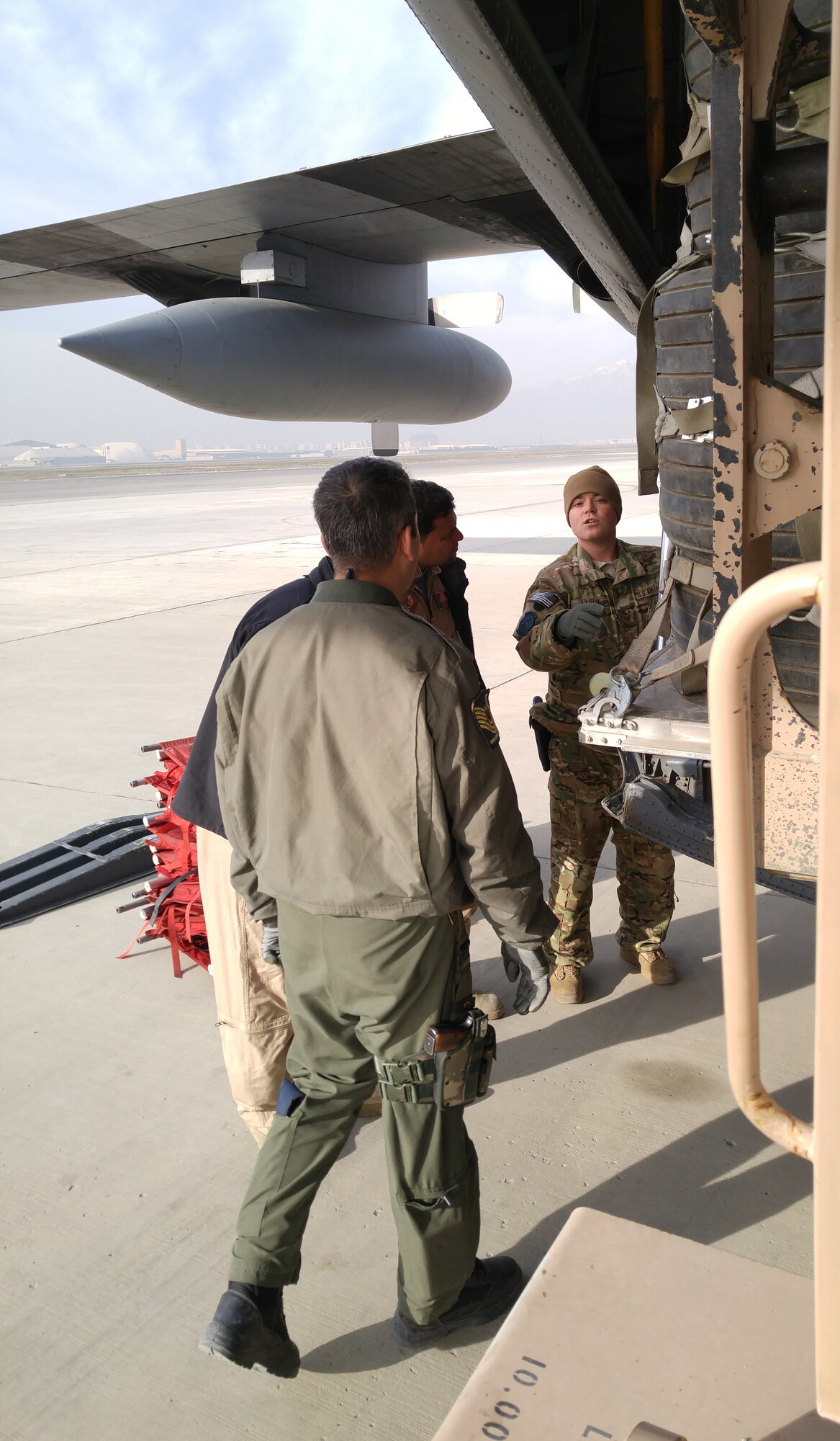 Tech. Sgt. Michael Lynch, evaluator loadmaster, 136th Airlift Wing, and Senior Master Sgt. Mehmet Aksoy, instructor loadmaster, Turkish air force, instruct Afghan students on the loading of a training pallet of old tires, December 3, 2015. Afghan air force students receive on-the-job training supervised by U.S. Air National Guard and coalition instructors during real-world cargo and passenger sorties. (U.S. Air National Guard photo by Master Sgt. Christopher Coarse, 538th Air Expeditionary Wing/released)