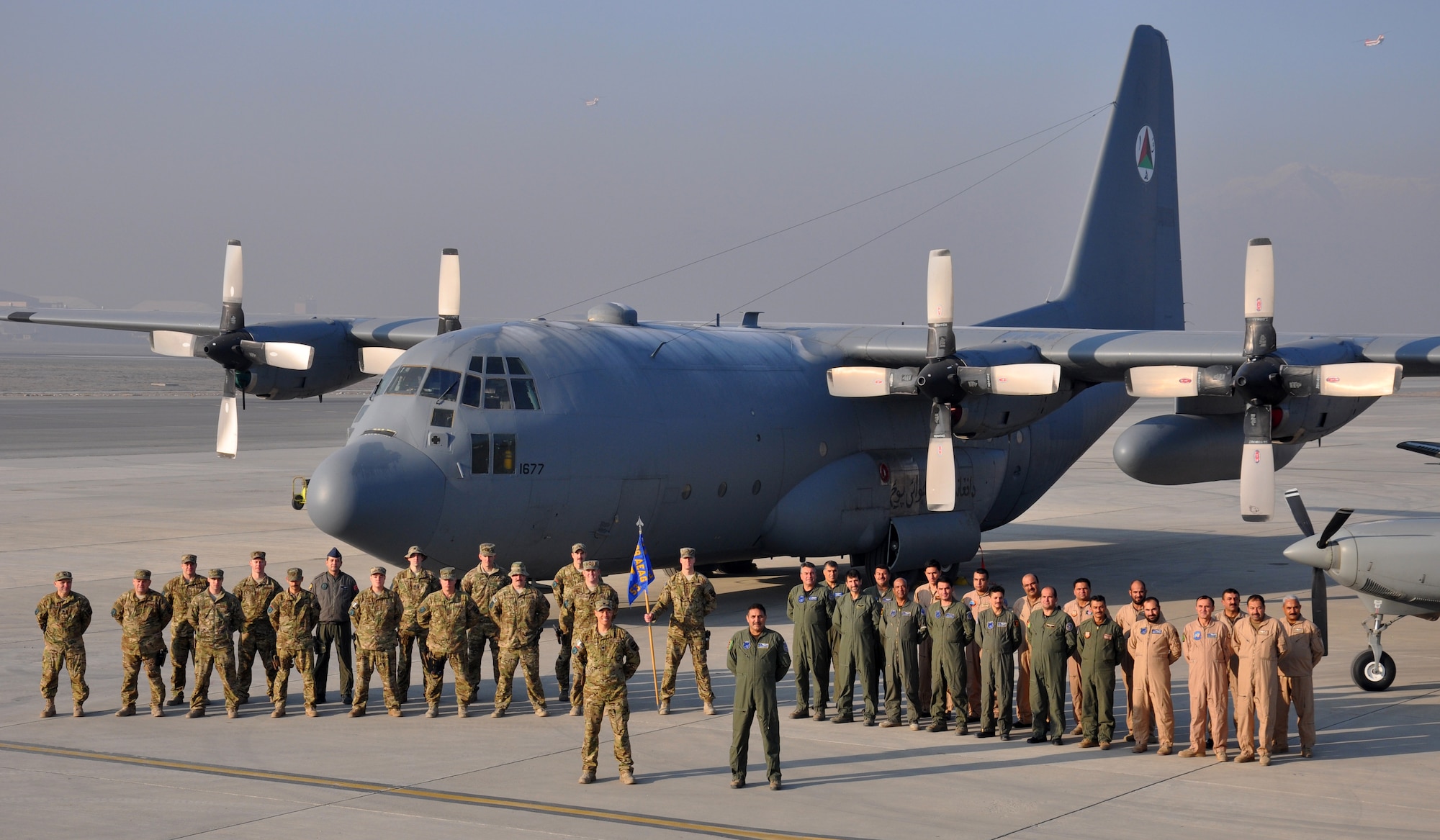 Members of the 538th Air Expeditionary Advisory Squadron and the Afghanistan Air Force's 373rd Fixed Wing Squadron pose for a group photo. U.S. Air National Guard and coalition advisors are evaluating and instructing Afghanistan Air Force C-130H Hercules aircraft operators as they build a mission-capable aviation squadron from the ground up. (U.S. Air Force photo by Capt. Edith Sakura, 538th Air Expeditionary Wing/released)