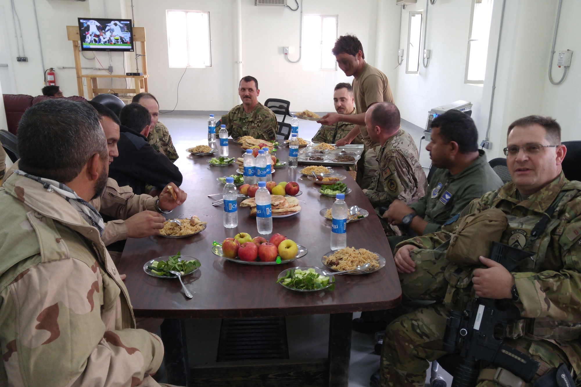 U.S. advisors from Train Advise Assist Command - Air and Afghan students enjoy a lunch together in an Afghan dining facility to build camaraderie and rapport November 22, 2015. Afghan air force students receive on-the-job training supervised by U.S. Air National Guard and Coalition advisors during real-world cargo and passenger sorties. (Some faces are blurred for security reasons) (U.S. Air National Guard photo by Master Sgt. Christopher Coarse, 538th Air Expeditionary Wing/released)