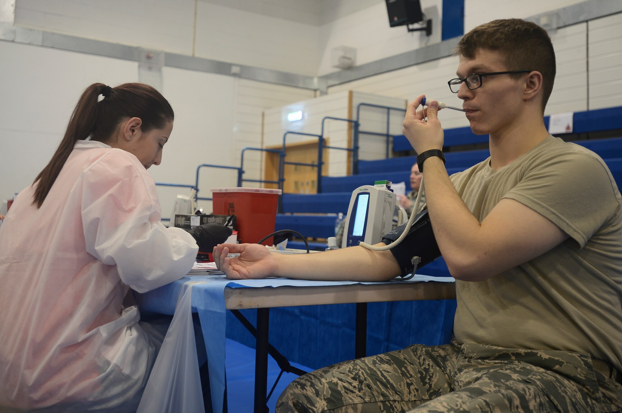 Airman 1st Class Edwin Keen, 48th Medical Support Squadron laboratory technician, is examined by Mariah Hockady, American Red Cross volunteer vitals technician, before donating blood at Royal Air Force Lakenheath, England, May 3, 2016. Blood donated by military donors helps keep the need to purchase blood down as well as ensuring the integrity and safety of the blood supply.  (U.S. Air Force photo by Senior Airman Dawn M. Weber/Released)
