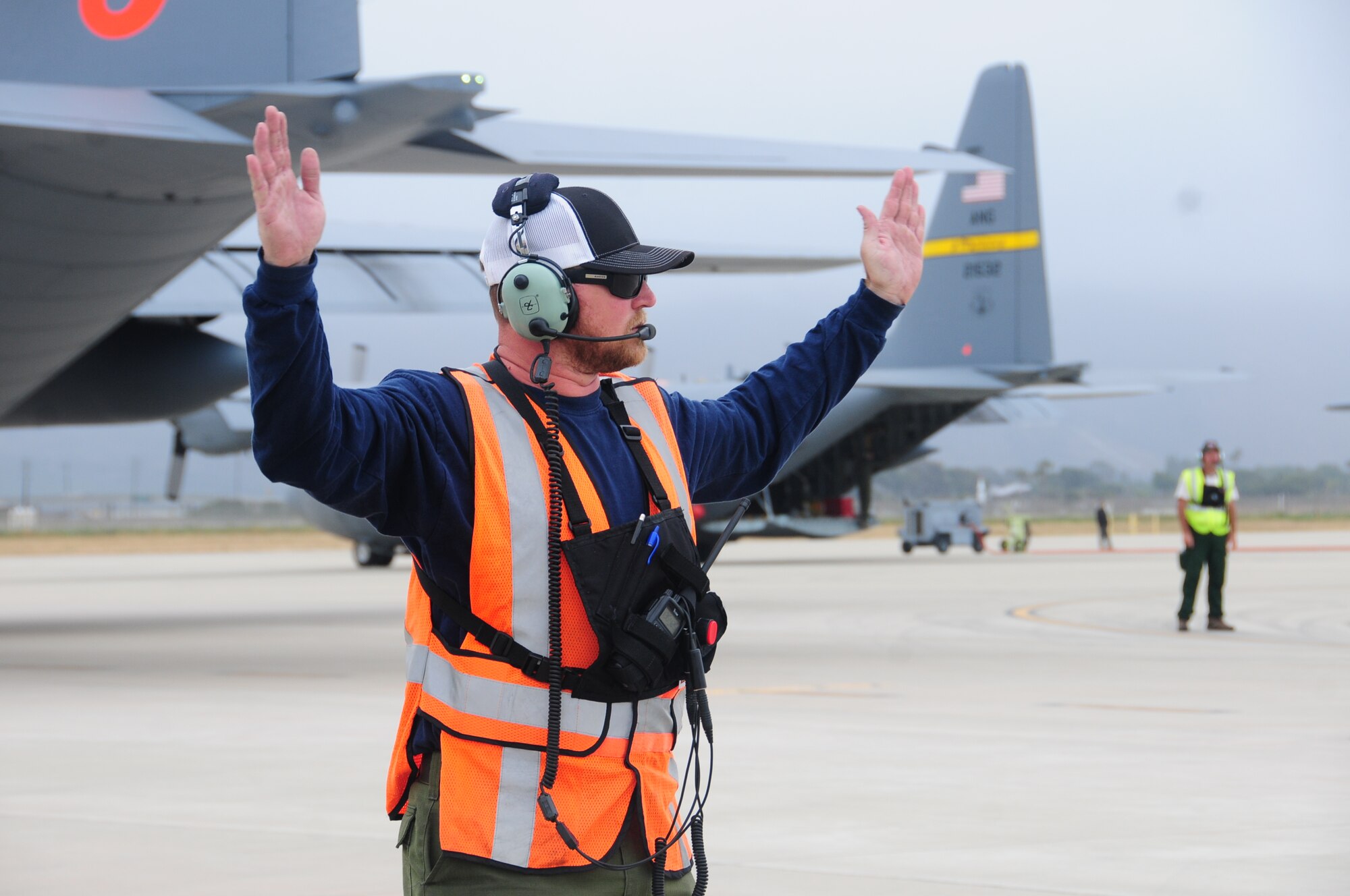 Assistant Tank Manager John Price from Gateway Tanker Base in Mesa, Arizona helps to direct a C-130 taxi out during MAFFS training at the 146th Airlift Wing in Port Hueneme, California on May 4, 2016. Air National Guard and Reserve units from across the U.S. convened for MAFFS (Modular Airborne Fire Fighting Systems)annual certification and training this week to prepare for the upcoming fire season in support of U.S. Forest Service. (U.S. Air National Guard photo by Senior Airman Madeleine Richards/Released)

