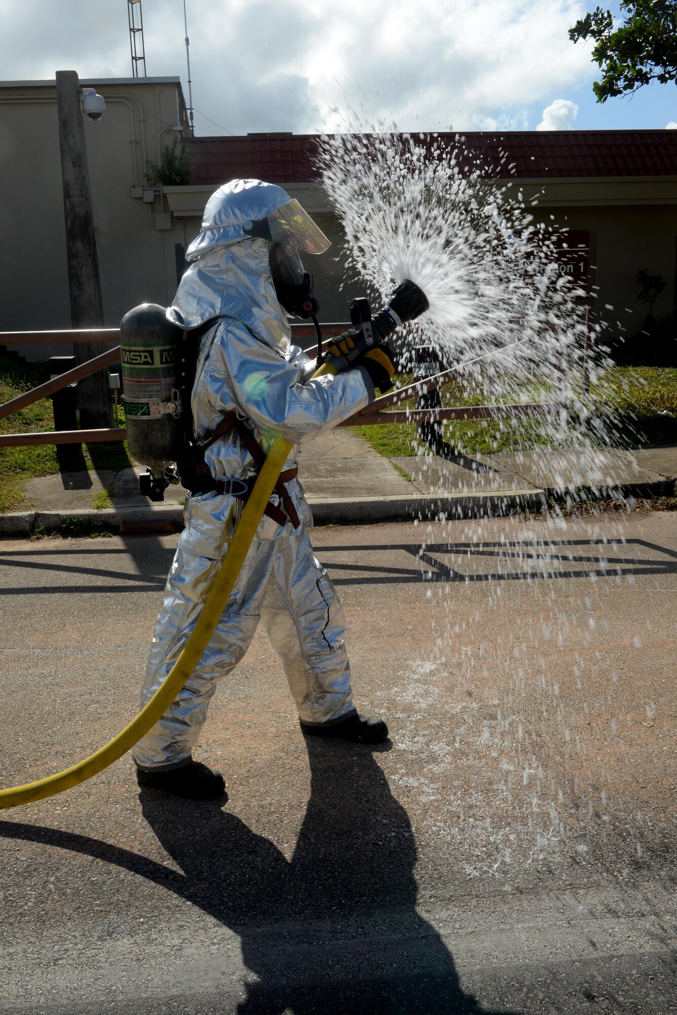 Airman 1st Class Kaleb Miranda, 36th Civil Engineer Squadron fire protection apprentice, utilizes a wide water spray from a firehose during a training course May 4, 2016, at Andersen Air Force Base, Guam. Miranda, along with his peers completed an obstacle course to test his strength and endurance using firefighting techniques while wearing personal protective equipment and a self-contained breathing apparatus. (U.S. Air Force photo by Airman 1st Class Alexa Ann Henderson)