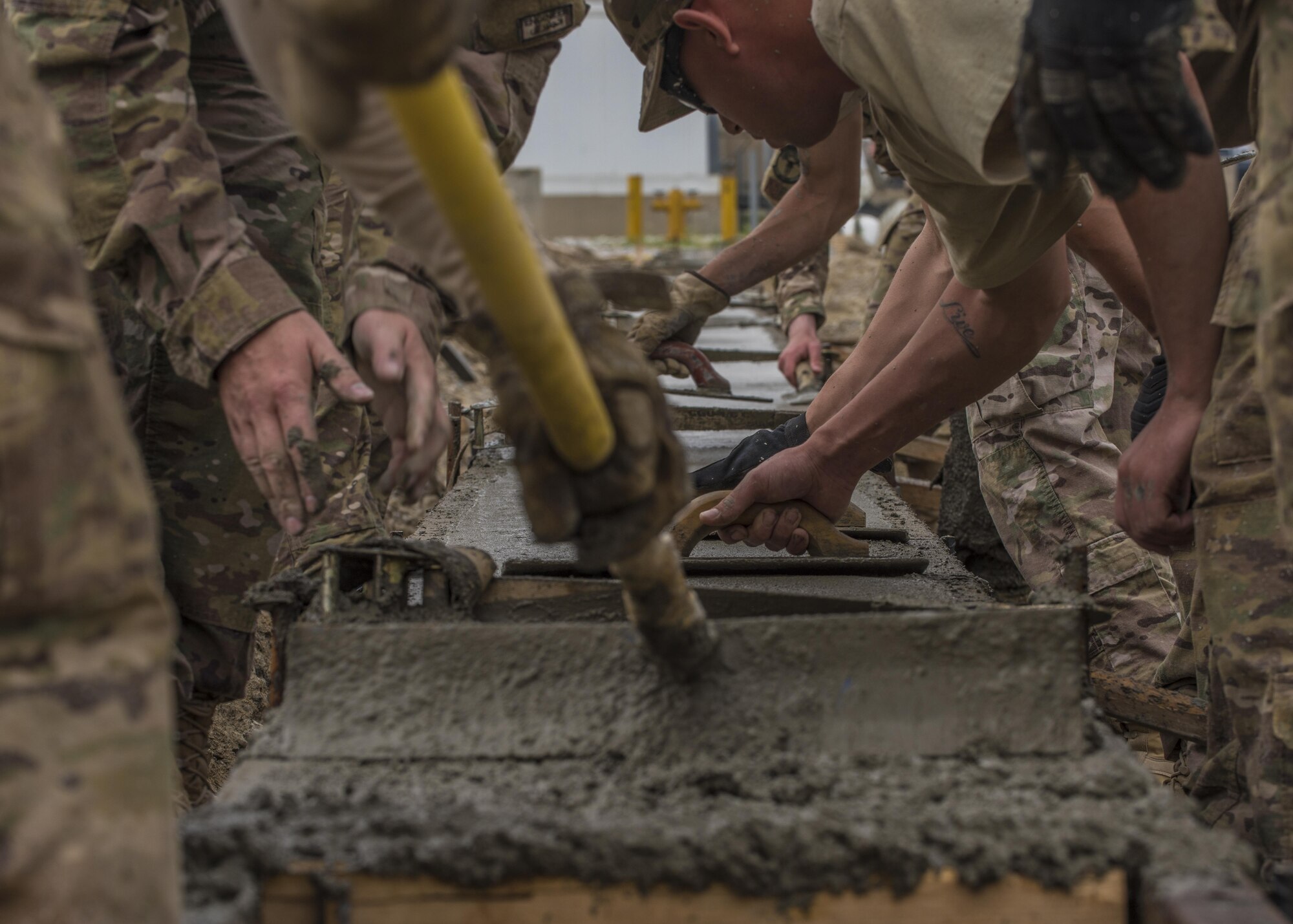 Members of the 455th Expeditionary Civil Engineer Squadron fill, edge, and smooth out new concrete for a footer at Bagram Airfield, Afghanistan, May 03, 2016. The 455th ECES personnel can construct runways and airfields in remote global locations in addition to maintaining facilities already in use. (U.S. Air Force photo by Senior Airman Justyn M. Freeman)