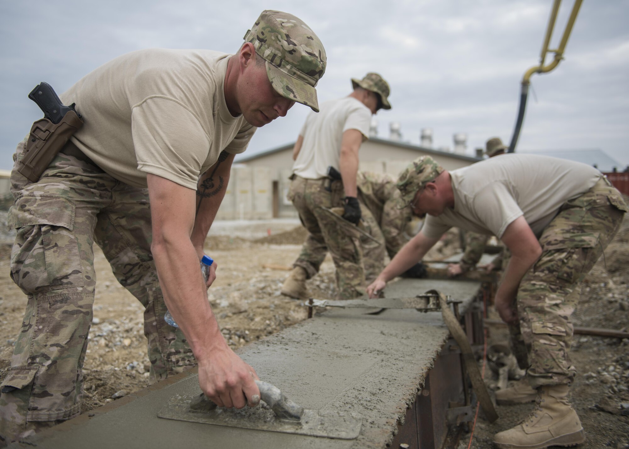 Staff Sgt. Jacob Skjei, 455th Expeditionary Civil Engineer Squadron Dirt Boy, smooths freshly laid concrete within a footer at Bagram Airfield, Afghanistan, May 03, 2016. Civil Engineer personnel can construct runways and airfields in remote global locations in addition to maintaining facilities already in use. (U.S. Air Force photo by Senior Airman Justyn M. Freeman)