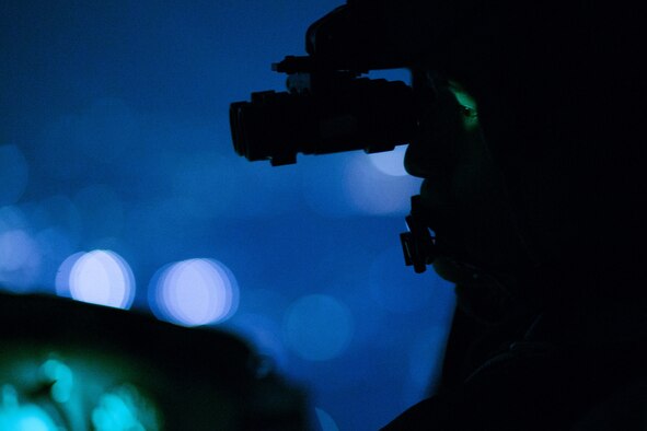Capt. Jonathan Bonilla, a 459th Airlift Squadron UH-1N Huey pilot, performs a visual confirmation using night vision goggles during a night training sortie over Tokyo, April 25, 2016. The 459th AS frequently trains on a multitude of scenarios in preparation for potential real-world contingencies and operations. (U.S. Air Force photo/Yasuo Osakabe)