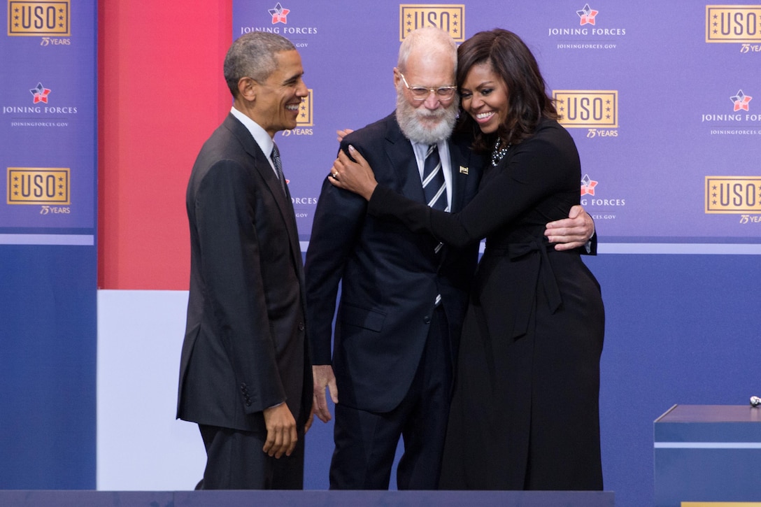 First Lady Michelle Obama hugs former Late Show Host David Letterman as President Barack Obama looks on during the comedy show celebrating the 75th anniversary of the USO and the 5th anniversary of the Joining Forces initiative at Joint Base Andrews near Washington, D.C., May 5, 2016. DoD photo by E.J. Hersom