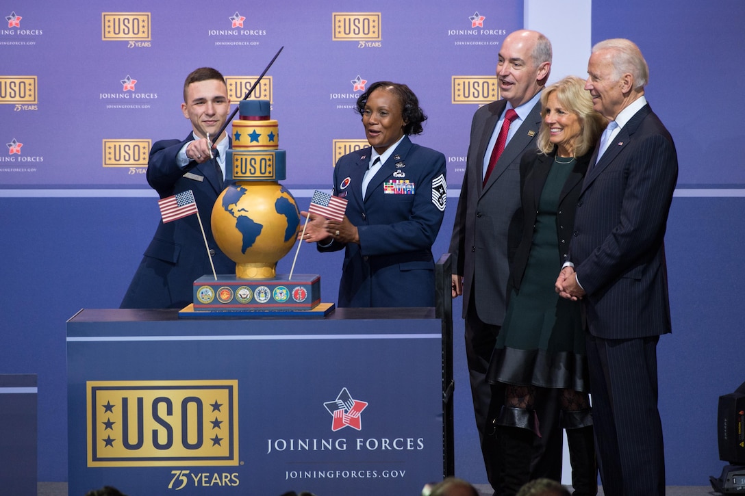 An airman cuts the cake during the comedy show celebrating the 75th anniversary of the USO and the 5th anniversary of the Joining Forces initiative at Joint Base Andrews near Washington, D.C,. May 5, 2016. DoD photo by E.J. Hersom