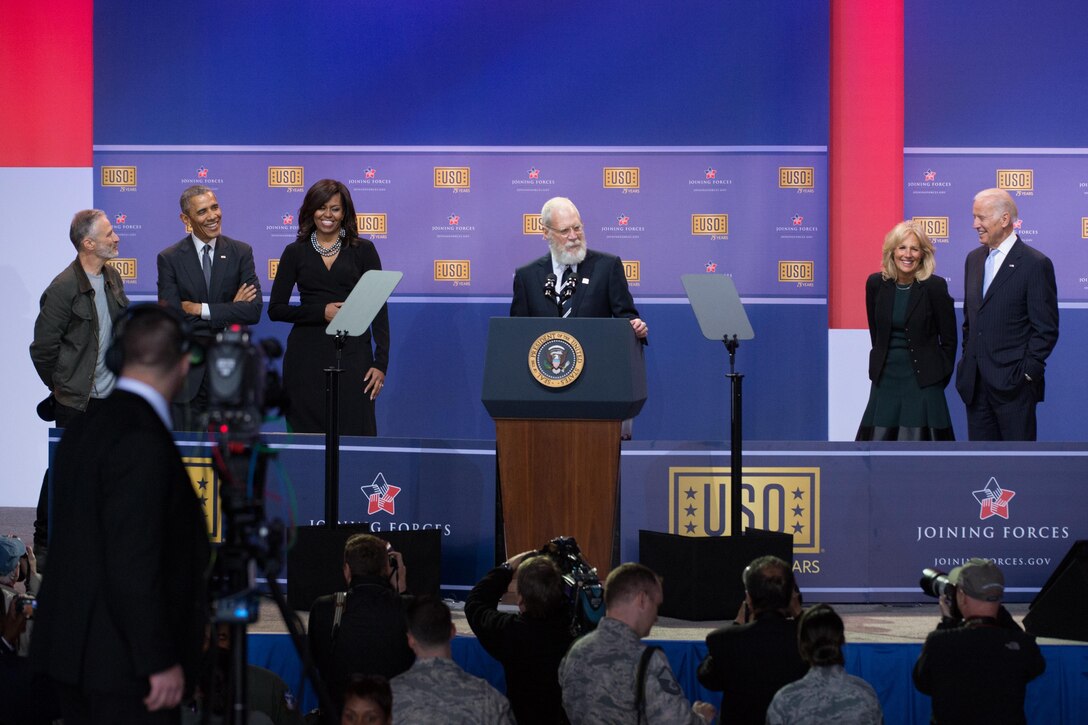 Former Late Show host and comedian David Letterman entertains the audience during the comedy show in celebration of the 75th anniversary of the USO and the 5th anniversary of the Joining Forces initiative at Joint Base Andrews near Washington, D.C,. May 5, 2016. On stage, from left: former Daily Show host and comedian Jon Stewart, President Barack Obama, First Lady Michelle Obama, Dr. Jill Biden, and Vice President Joe Biden. DoD photo by E.J. Hersom