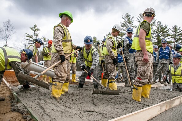 Airmen from the 110th Attack Wing and Marine reservists work together to build a porch for a new dining facility at Camp Hinds, Maine, May 3, 2016. The Airmen participated in the Innovative Readiness Training at Camp Hinds. IRT combines training with community needs, helping Airmen achieve wartime readiness while also helping the community. (U.S. Air National Guard photo/Airman Tiffany Clark)