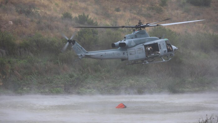 An aircraft hovers over Las Pulgas Lake in California during Wildland Firefighting Exercise 2016 hosted by Marine Corps Base Camp Pendleton, May 5. The Wildland Firefighting Exercise 2016 combines elements of aviation and ground units from Camp Pendleton, 3rd Marine Air Wing, Navy Region Southwest, The California Department of Forestry and Fire Protection, and the San Diego's Sheriff's Department. 