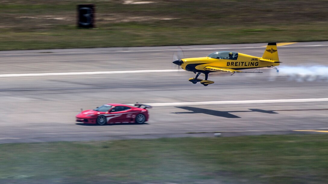 Yoshihide Muroya takes off as he races a Ferrari down the taxi way during the Marine Corps Air Station Iwakuni Friendship Day 2016 Air Show, May 5, 2016. As the first Asian pilot in the Red Bull Air Race World Championship in 2009, Yoshihide has helped raise the popularity of the sport in East Asia, particularly in his home country of Japan. This annual event showcases a variety of static displays, aviation performances and demonstrations, and provides food and entertainment for guests of the largest single-day event in Iwakuni. 