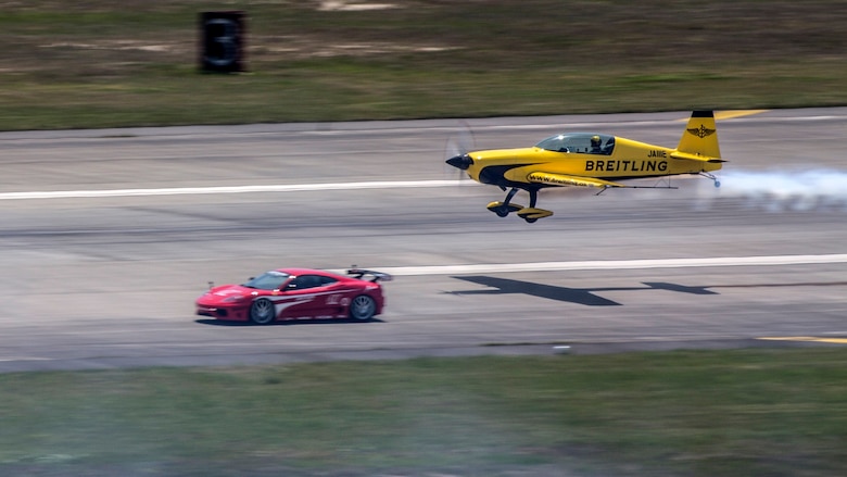 Yoshihide Muroya takes off as he races a Ferrari down the taxi way during the Marine Corps Air Station Iwakuni Friendship Day 2016 Air Show, May 5, 2016. As the first Asian pilot in the Red Bull Air Race World Championship in 2009, Yoshihide has helped raise the popularity of the sport in East Asia, particularly in his home country of Japan. This annual event showcases a variety of static displays, aviation performances and demonstrations, and provides food and entertainment for guests of the largest single-day event in Iwakuni. 