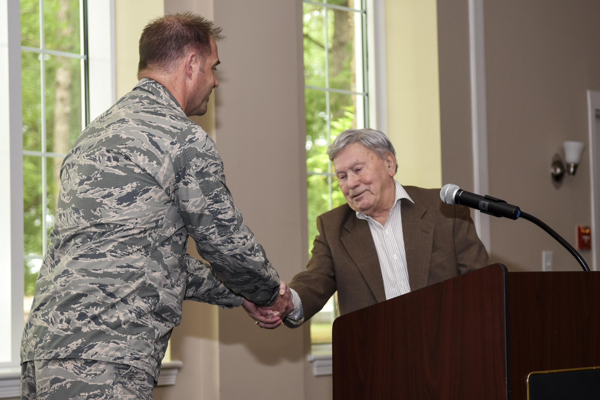 Col. Andrew Bernard (left), 4th Fighter Wing vice commander, shakes hands with Morris Glass, a Holocaust survivor, May 4, 2016, at Seymour Johnson Air Force Base, North Carolina. Glass recounted his story of surviving through several concentration camps during the Nazi regime before being liberated by the American Army. (U.S. Air Force photo by Airman Shawna L. Keyes/Released)
